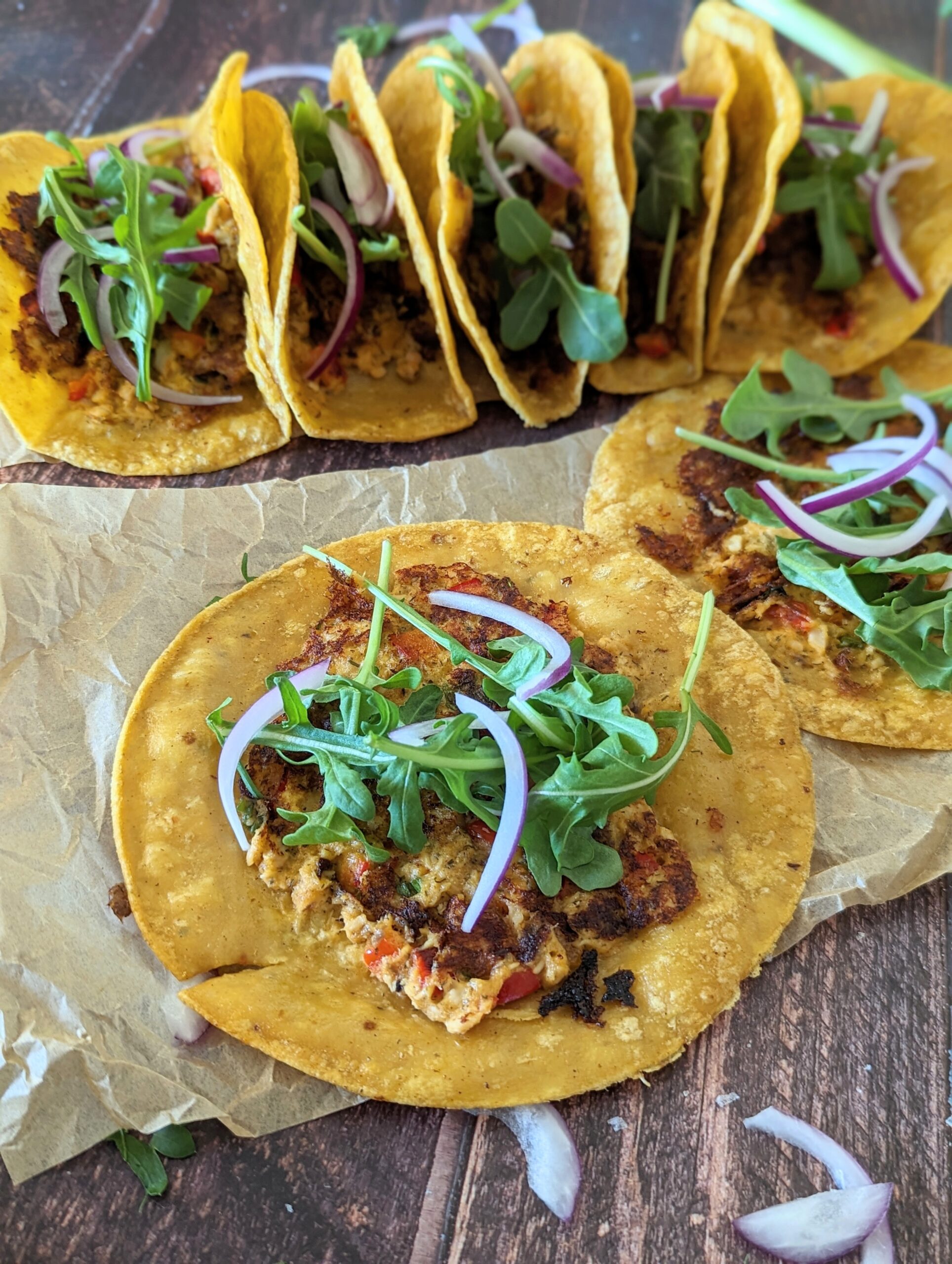 Tacos laying on a wood table